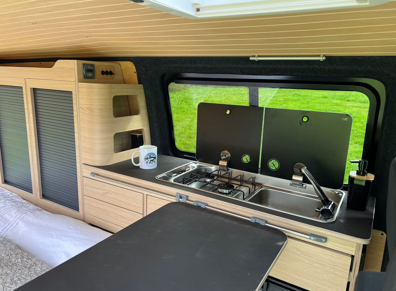 Meuble latéral gauche et banquette clic-clac 120 cm Exokit en stratifié chêne Vicenza dans le VW T6 "Louis" aménagé par Van Passion